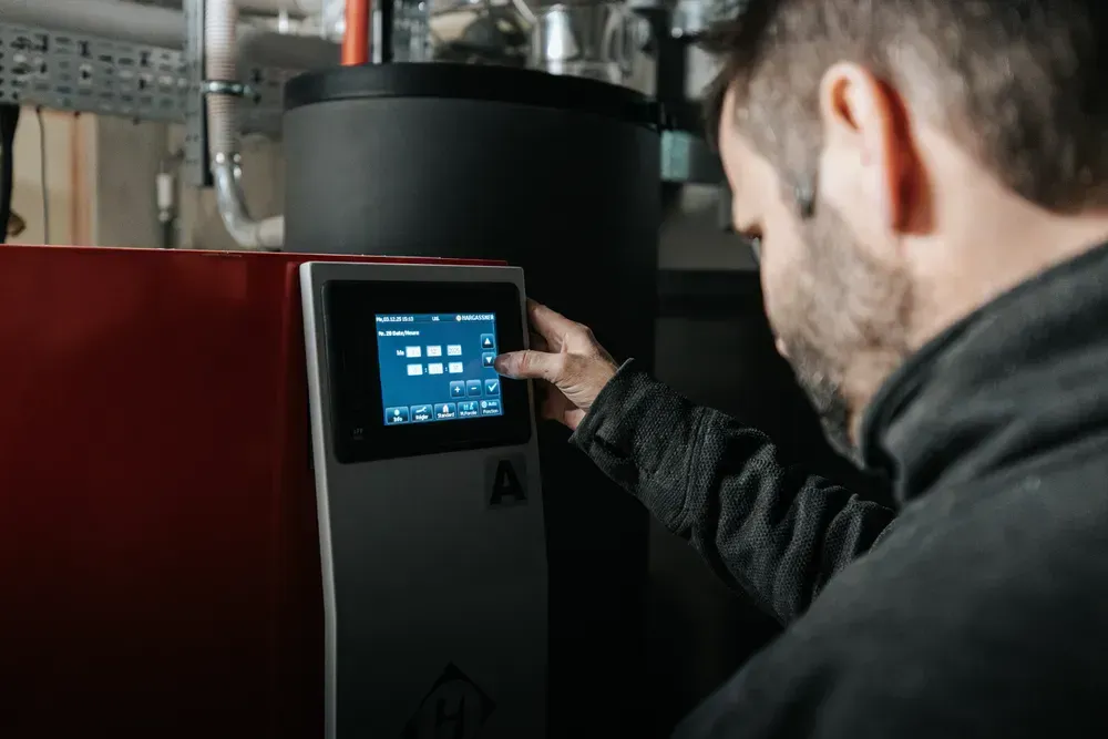 Technicien chauffagiste entrain de régler le compteur d’une chaudière