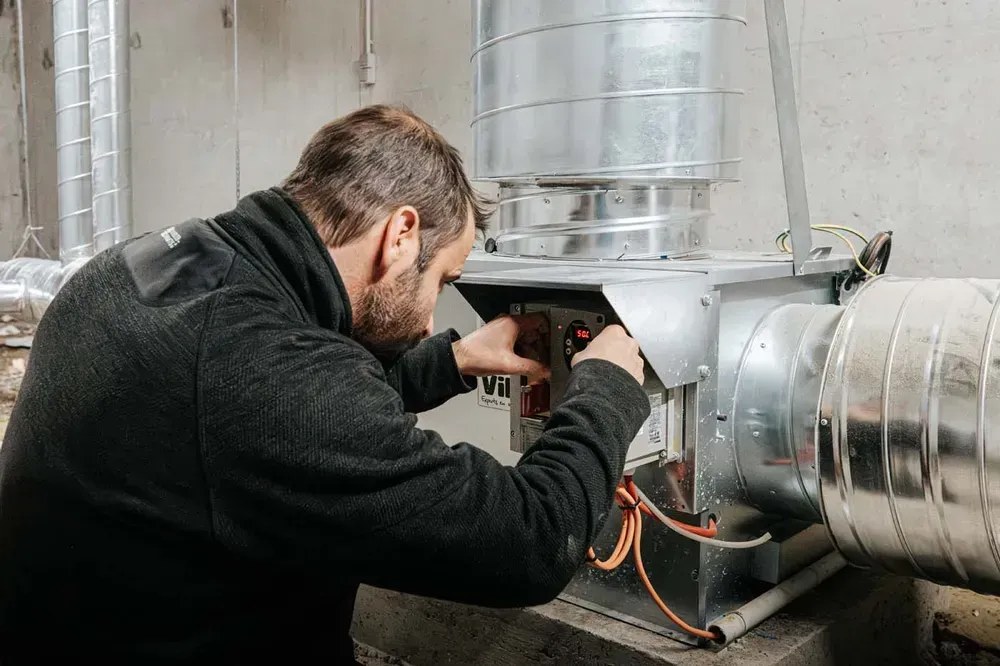 Chauffagiste ACL entrain de réaliser un contrôle des circuits d’une pompe à chaleur